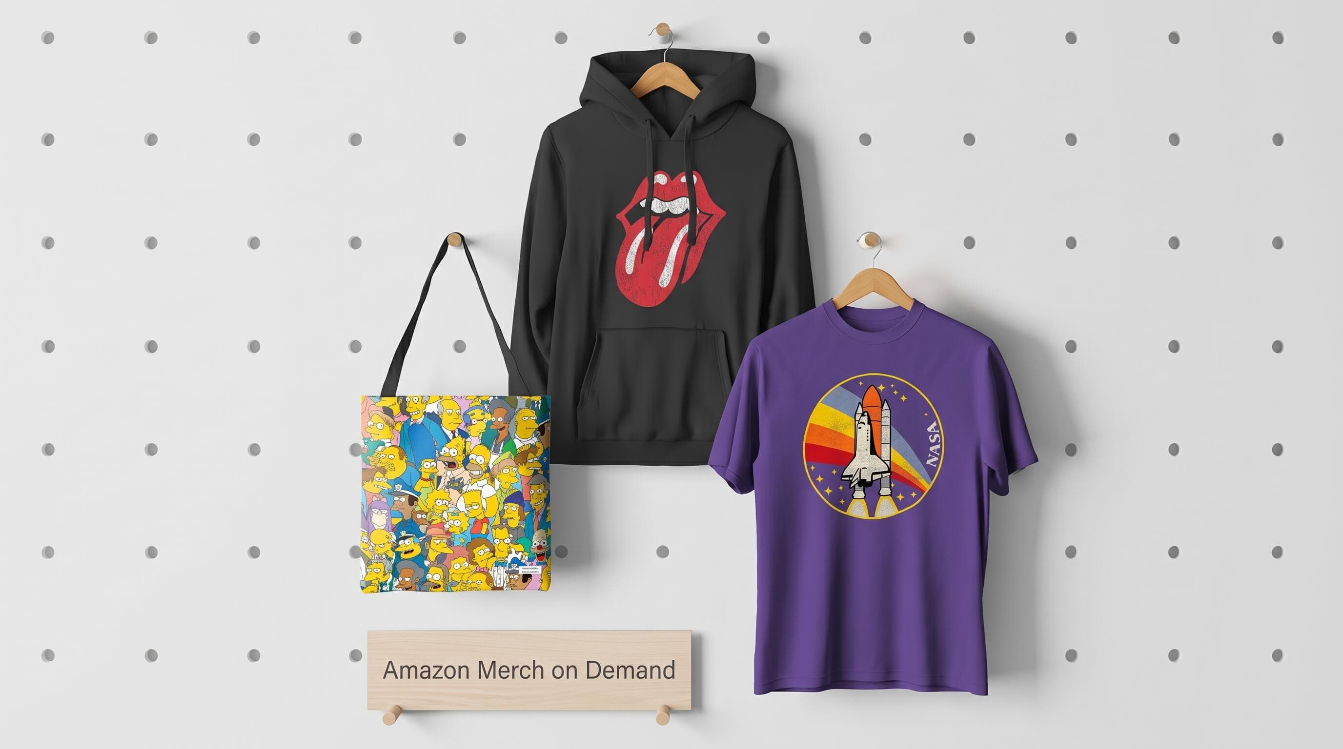 Amazon Merch on Demand licensed apparel: a graphic hoodie, tote bag and t-shirt on a pegboard display